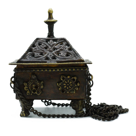 Decorative metal box with intricate designs and a chain on a white background
