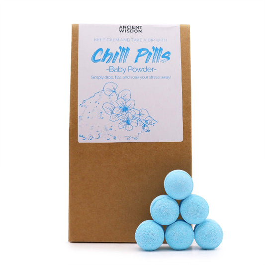 Blue bath bombs in front of a brown package labeled 'Chill Pills' on a white background