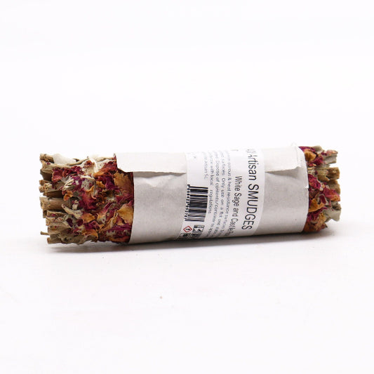 Rolled sage and sweetgrass smudge stick with a label on a white background