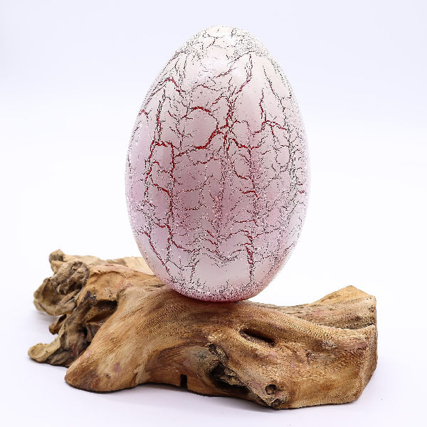 Decorative egg with red vein-like patterns on a white background