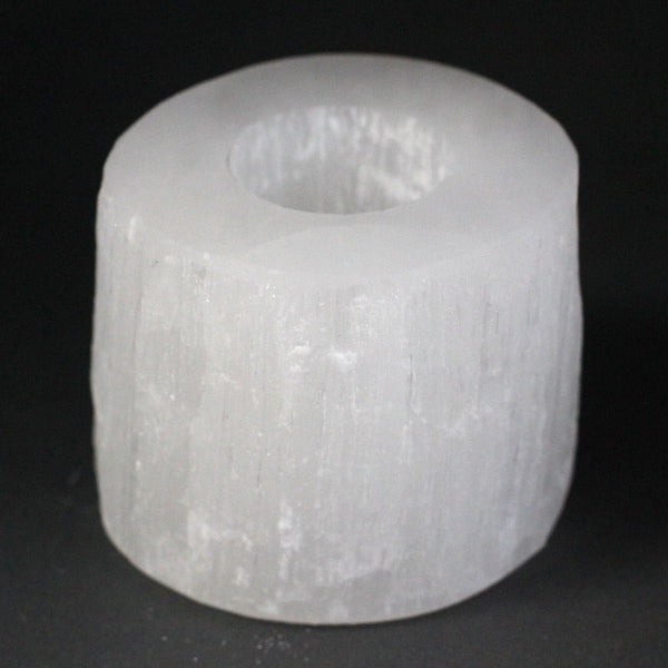 White cylindrical object with a central hole on a black background