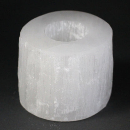 White cylindrical object with a central hole on a black background
