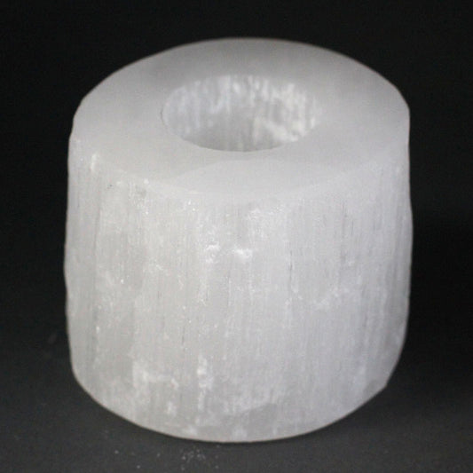 White cylindrical object with a central hole on a black background