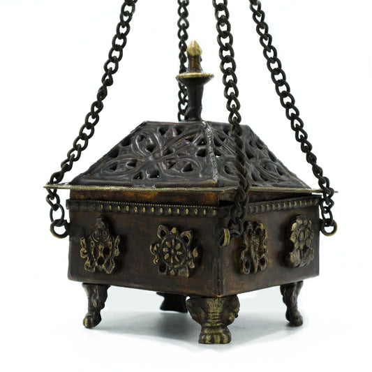 Decorative bronze incense burner with intricate designs on a white background