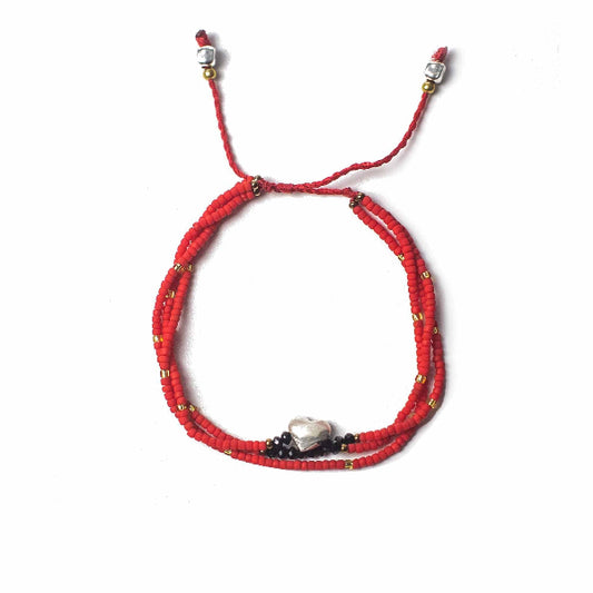 Red beaded bracelet with silver clasp on a white background