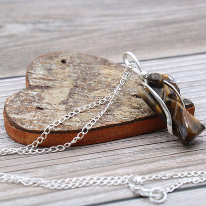 Necklace with a tiger's eye stone on a wooden heart-shaped block