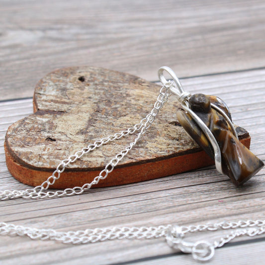 Necklace with a tiger's eye stone on a wooden heart-shaped block