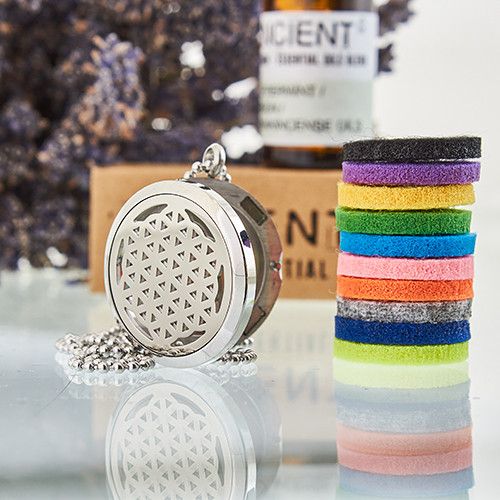 Aromatherapy diffuser, essential oil bottle, and colorful hair ties on a reflective surface.