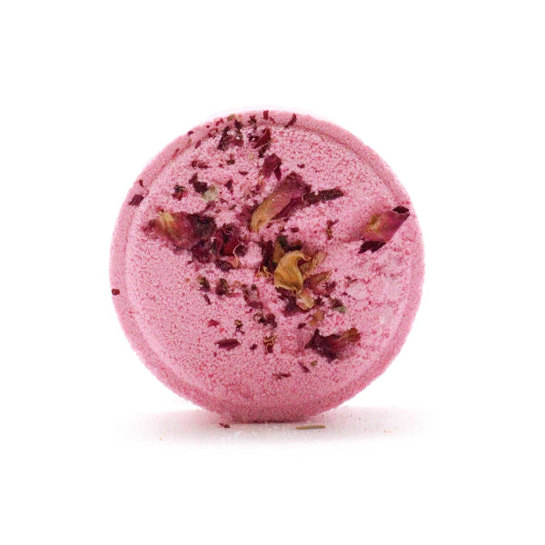 Pink bath bomb with rose petals on a white background