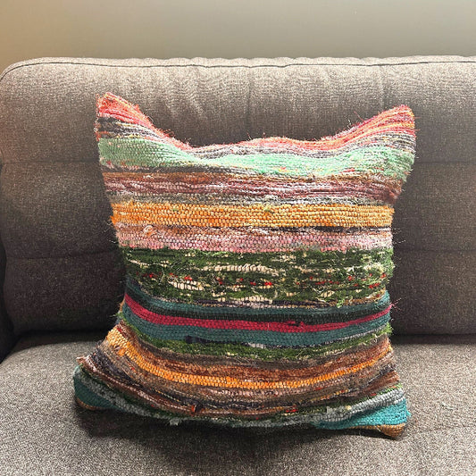 Multicolored striped pillow on a gray sofa