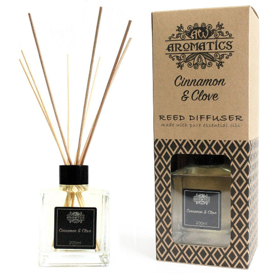 Reed diffuser with cinnamon and clove scent next to its packaging on a white background