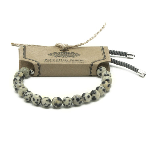 Bracelet with dalmatian jasper beads on a cardboard packaging with brand name.