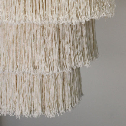 Close-up of a textured fabric with fringes on a plain background
