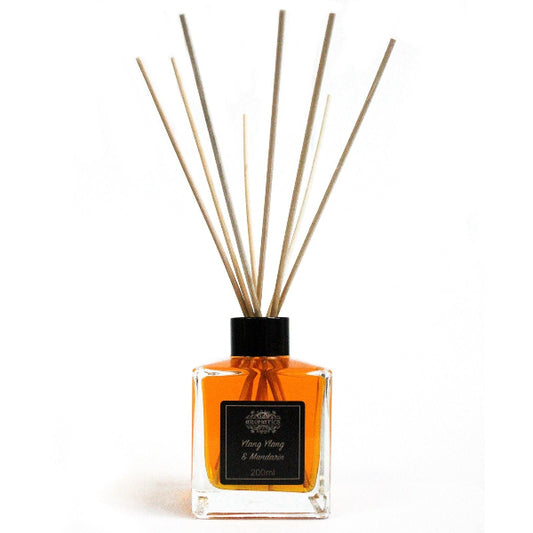 Reed diffuser with wooden sticks in a clear bottle on a white background