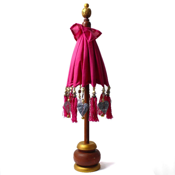 Decorative lamp with pink shade and tassels on a white background