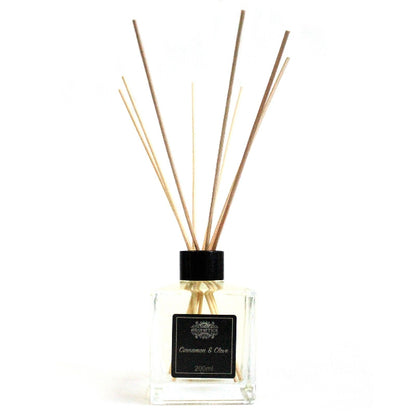 Reed diffuser with wooden sticks and a black cap on a white background
