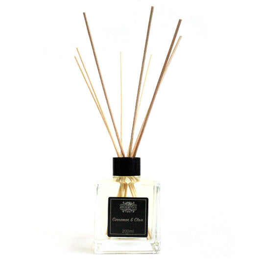 Reed diffuser with wooden sticks and a black cap on a white background