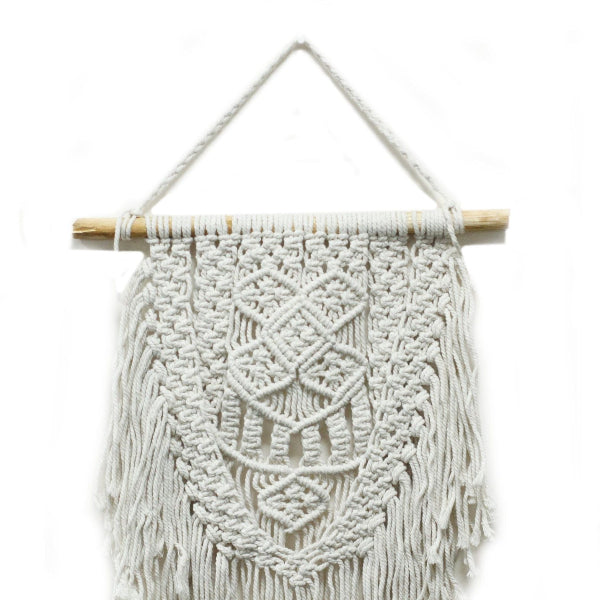 Macrame wall hanging with geometric pattern on a white background