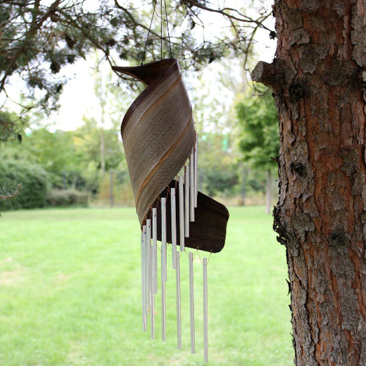 Decorative wind chime hanging from a tree in a park setting