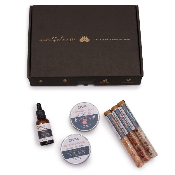 Gift set with mindfulness theme including a bottle, containers, and sticks on a white background.