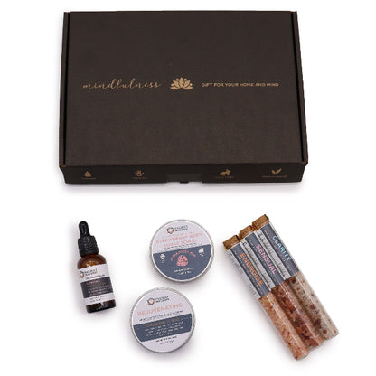 Gift set with mindfulness theme including a bottle, containers, and sticks on a white background.