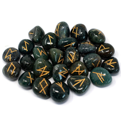 Set of black stones with gold runes on a white background