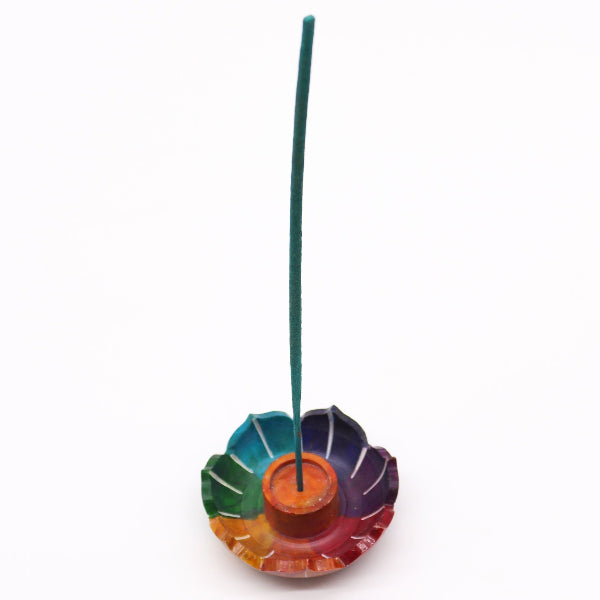 Colorful incense holder with a single green incense stick on a white background