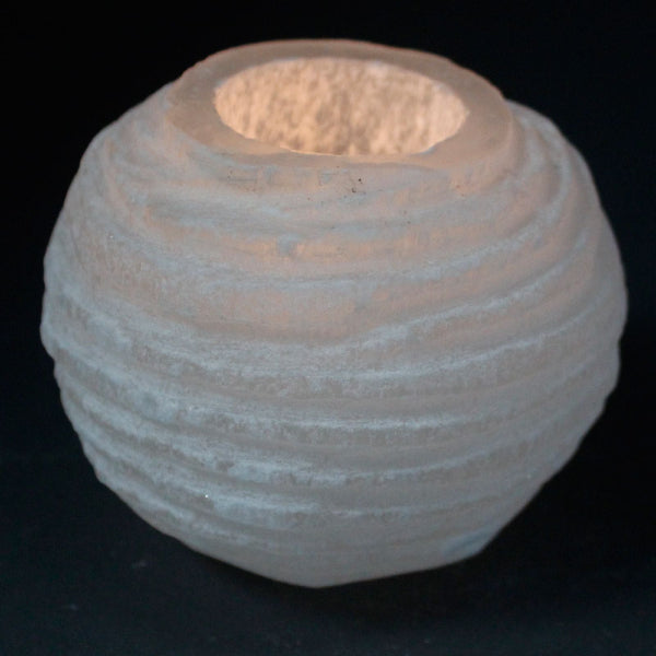 Textured ceramic candle holder on a black background