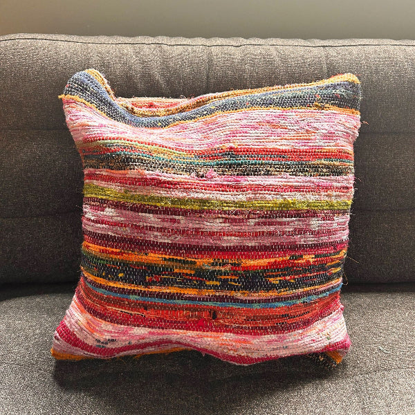 Multicolored textured pillow on a gray couch