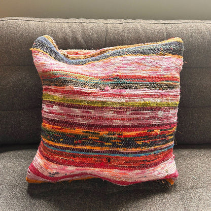 Multicolored textured pillow on a gray couch
