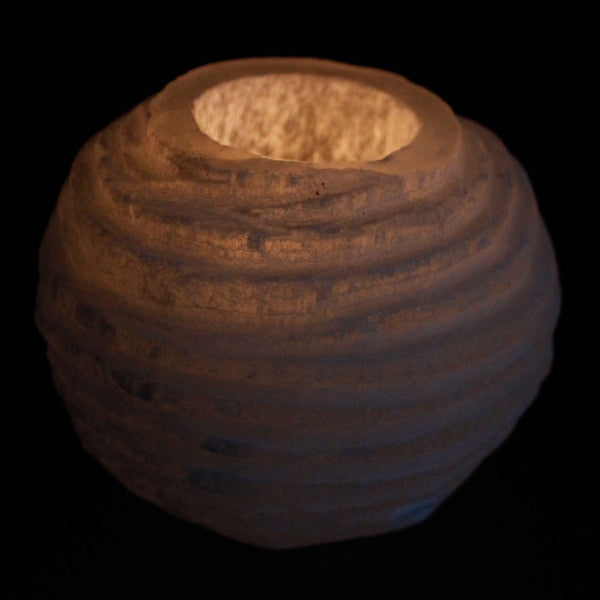 Selenite candle holder with a textured surface on a black background
