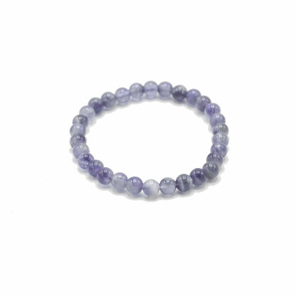 Beaded bracelet with purple and white stones on a white background
