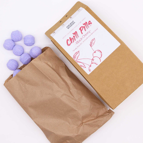 Brown paper bag with purple balls and a white label on a white background