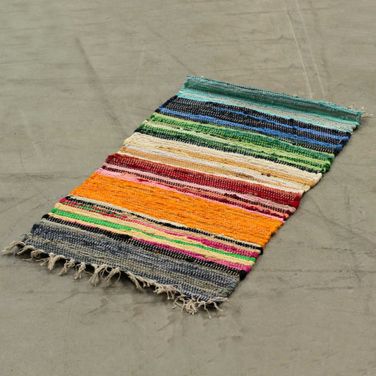 Multicolored striped rug on a concrete floor