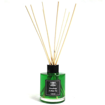 Green diffuser bottle with wooden sticks on a white background