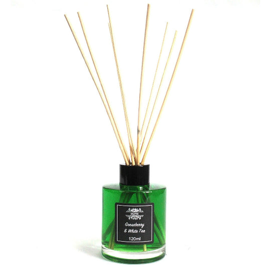 Green diffuser bottle with wooden sticks on a white background