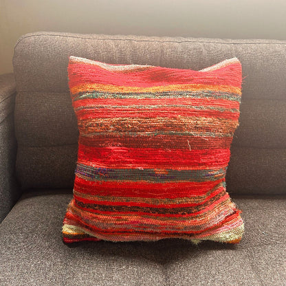 Multicolored striped pillow on a gray sofa