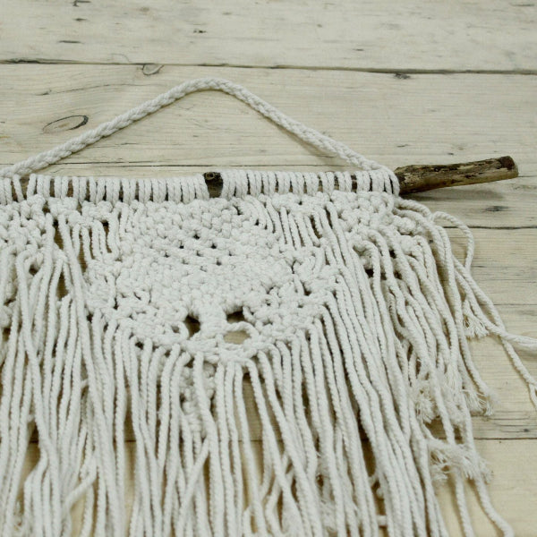 Macrame wall hanging on a wooden surface