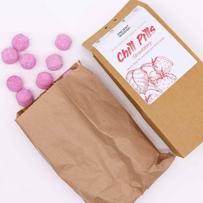 Pink gummy bears in an open brown cardboard box with a label on a white background