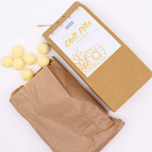Kraft paper packaging with white label and yellow spherical items on a white background