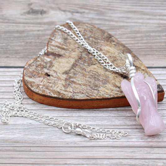 Necklace with a pink pendant on a wooden surface