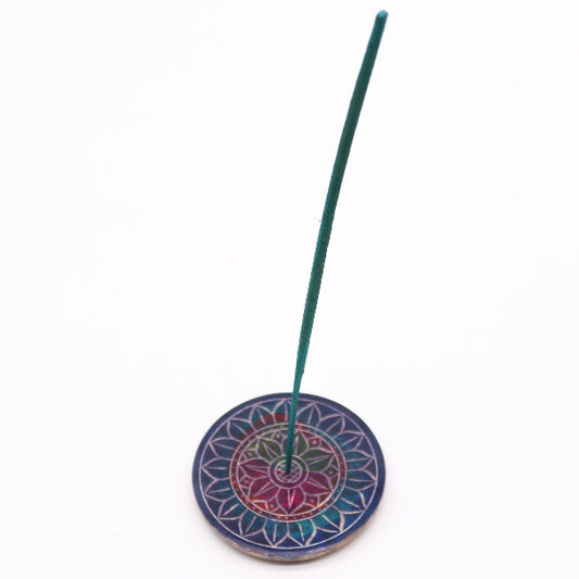 Incense stick on a colorful circular holder against a white background