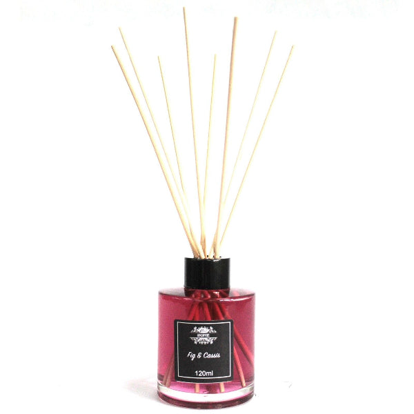 Reed diffuser with wooden sticks in a pink bottle on a white background