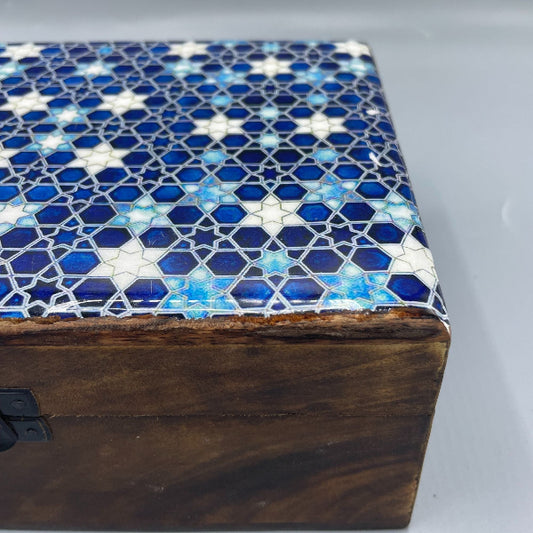 Wooden box with a mosaic lid featuring blue and white geometric pattern on a gray background
