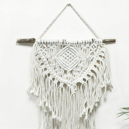 Macrame wall hanging with white yarn and wooden sticks on a white background