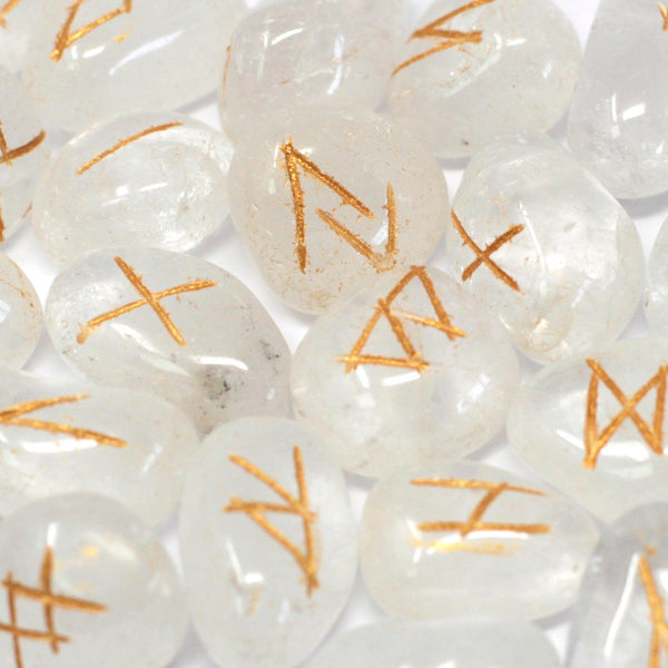 Close-up of white stones with orange runes on a white background