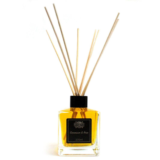 Reed diffuser with wooden sticks in a clear bottle on a white background