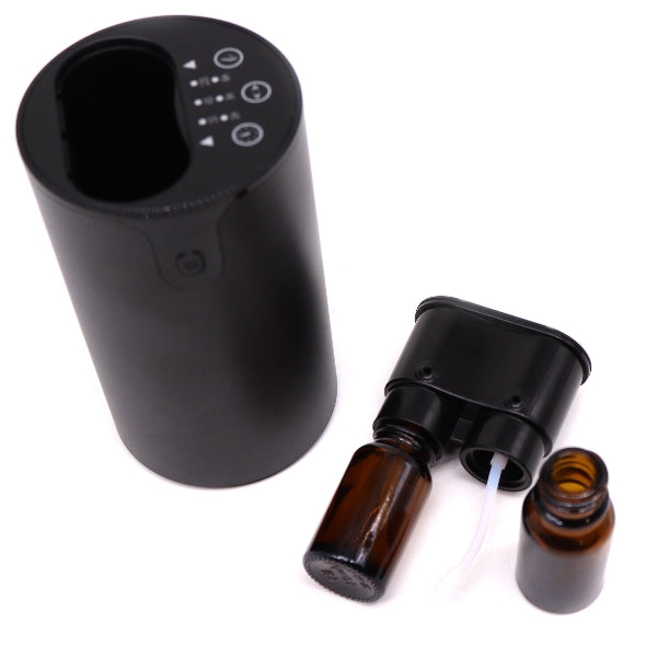 Black electronic device with brown glass bottles on a white background