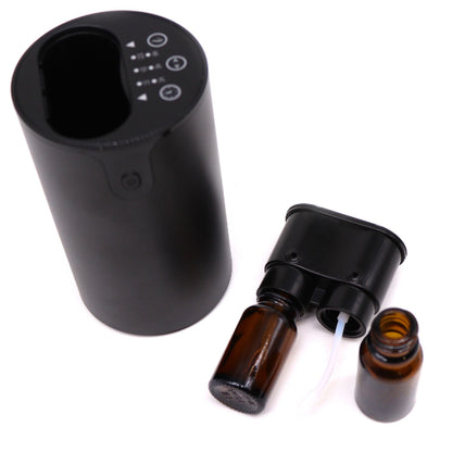 Black electronic device with brown glass bottles on a white background