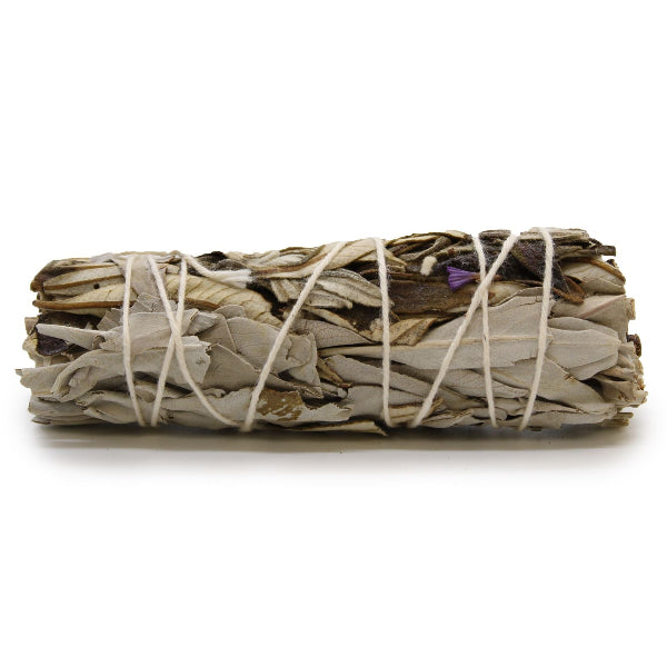 Bundled sage sticks tied with twine on a white background